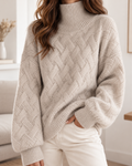 Pull beige en maille texturée pour femme à col montant, motif tressé et manches longues, coupe décontractée.