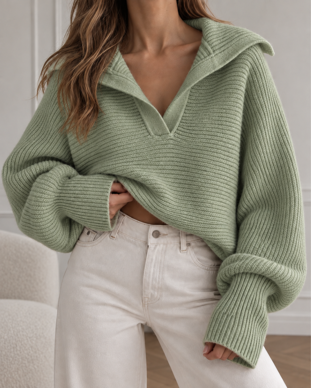 Pull oversize femme olive en maille côtelée, avec col large ouvert et manches longues amples.
