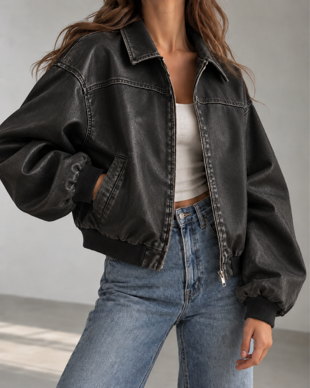 Veste femme noire en cuir, coupe oversize style bomber, avec col chemise, fermeture zippée et manches longues.