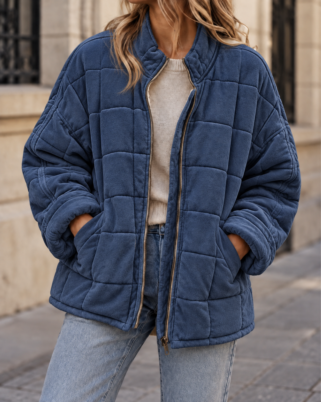 Veste matelassée femme bleu marine, coupe oversize avec col montant, manches longues, fermeture zippée et poches latérales.