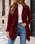 Manteau mi-long rouge vin pour femme, à coupe asymétrique, avec larges revers drapés, manches longues et ouverture sur le devant.