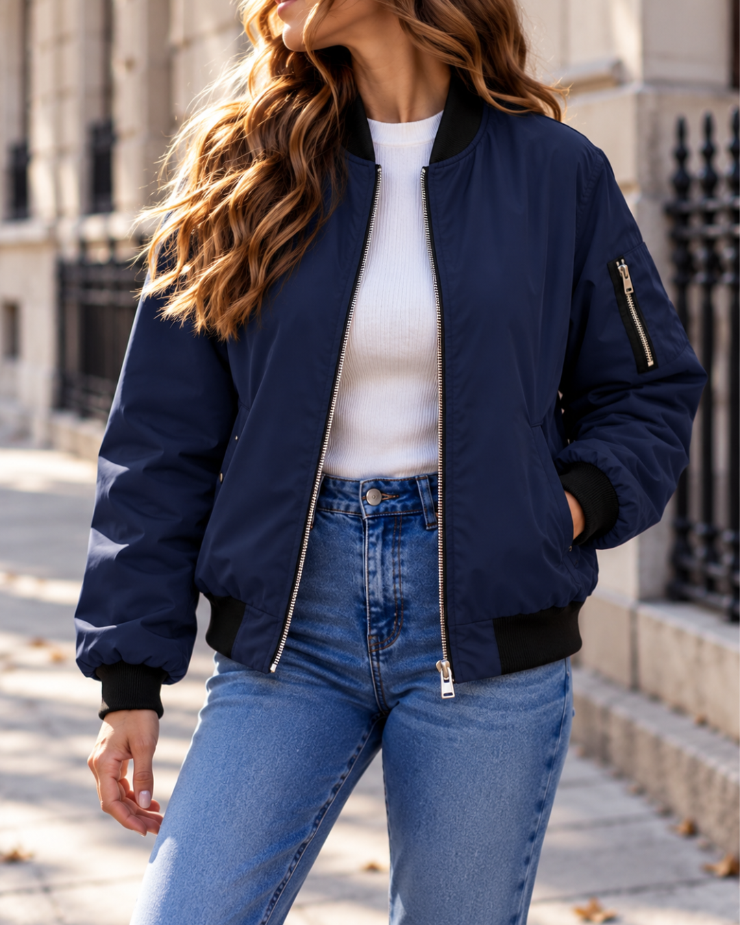 Blouson bomber femme marine à fermeture zippée, col montant côtelé, manches longues, poche zippée sur la manche et coupe décontractée.