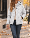 Veste femme ivoire à motif floral discret, avec capuche ajustable, fermeture zippée, manches longues et poches latérales zippées.