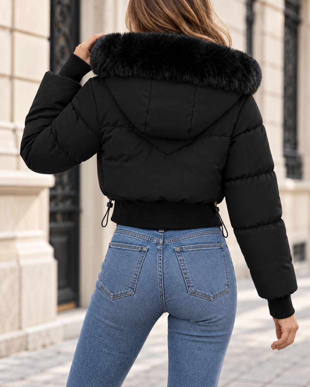 Doudoune courte femme noir, matelassée avec capuche bordée de fausse fourrure, fermeture zippée, manches longues à poignets côtelés et taille ajustable.