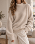 Pull oversize en cachemire ivoire clair pour femme, à col roulé et manches longues, coupe ample et finition en maille douce.