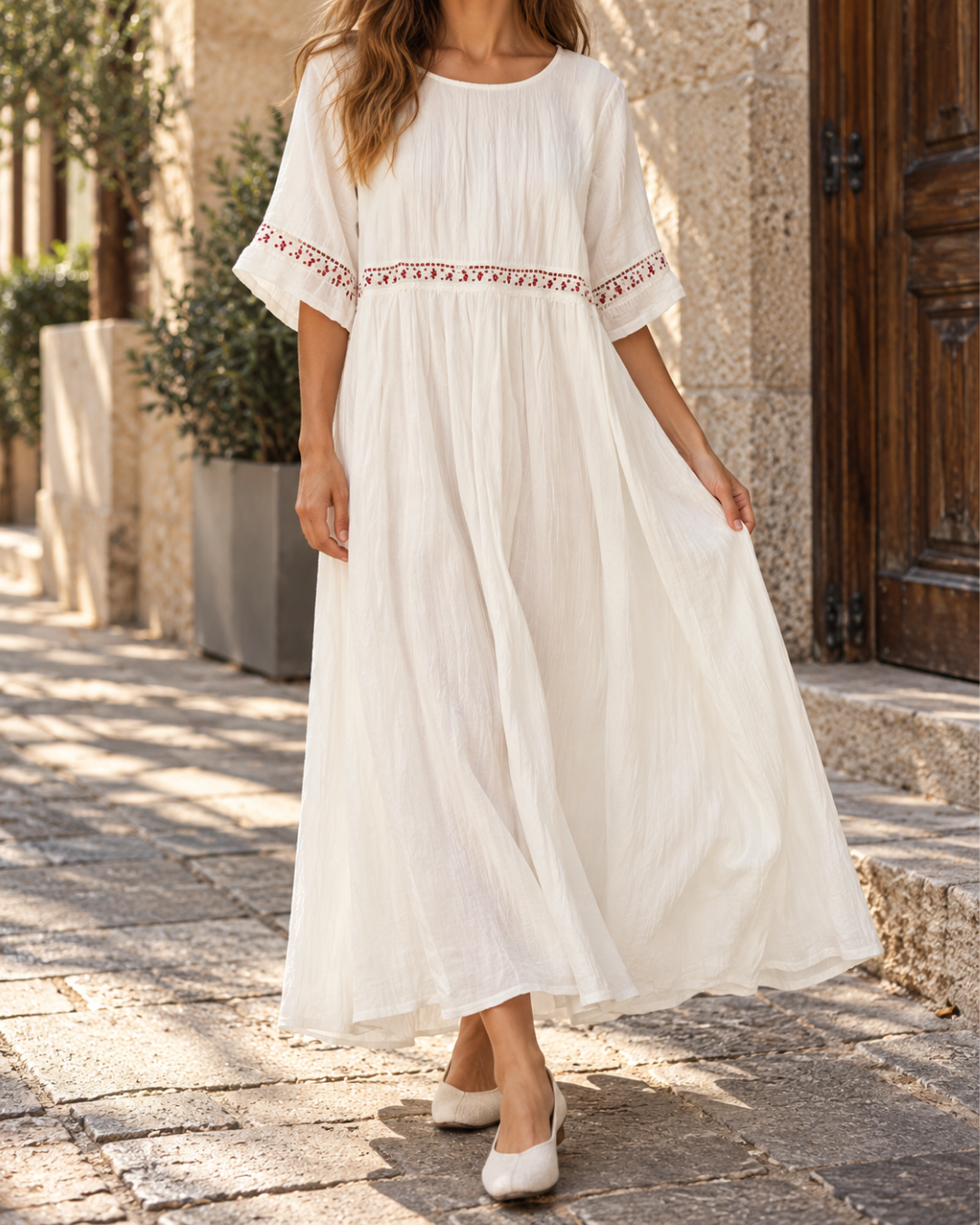 Robe longue femme blanche à col rond, manches courtes amples, taille froncée, détails brodés rouges et jupe fluide évasée.