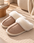 Chaussons femme beige en suédine à bout arrondi, intérieur fourré en fausse fourrure écrue, large revers duveteux et couture centrale apparente.